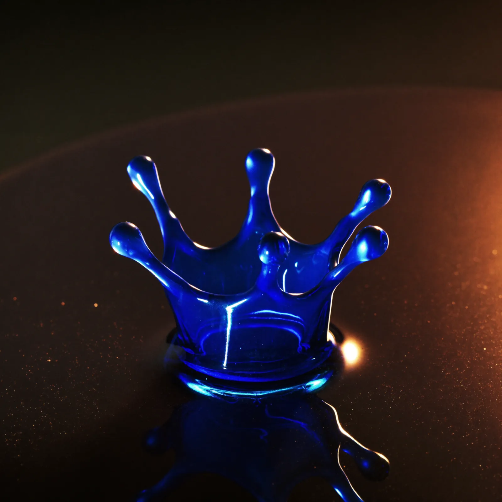 A single drop of blue serum frozen in a crown splash